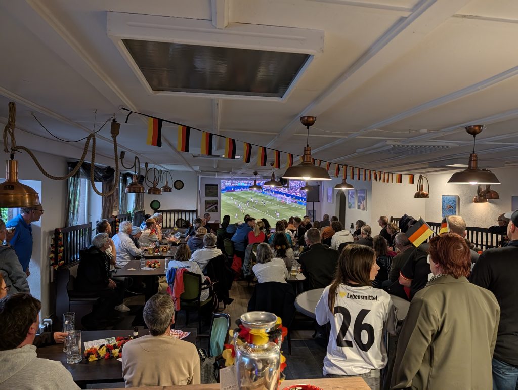 Voller Saal beim WM-Spiel 2026, Deutschlandfahnen unter der Decke